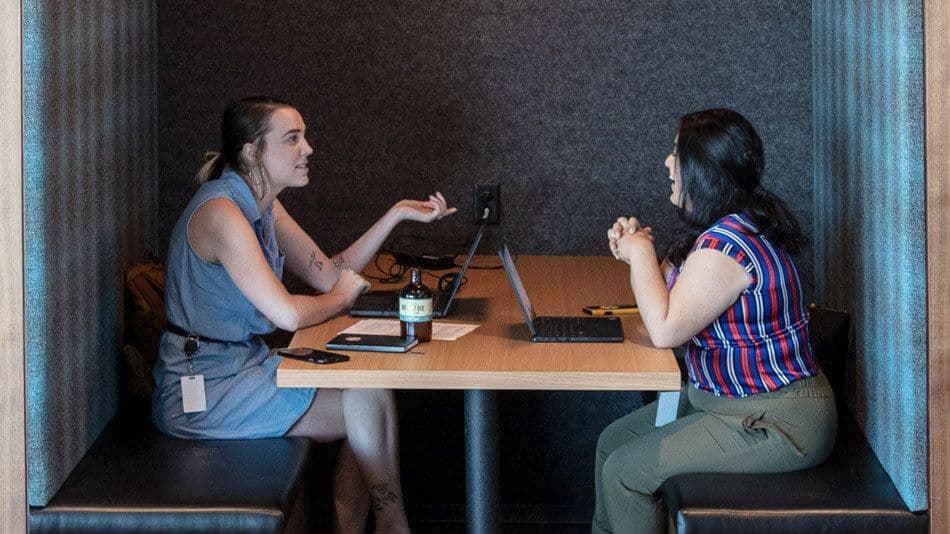 Three people at a table looking at laptops